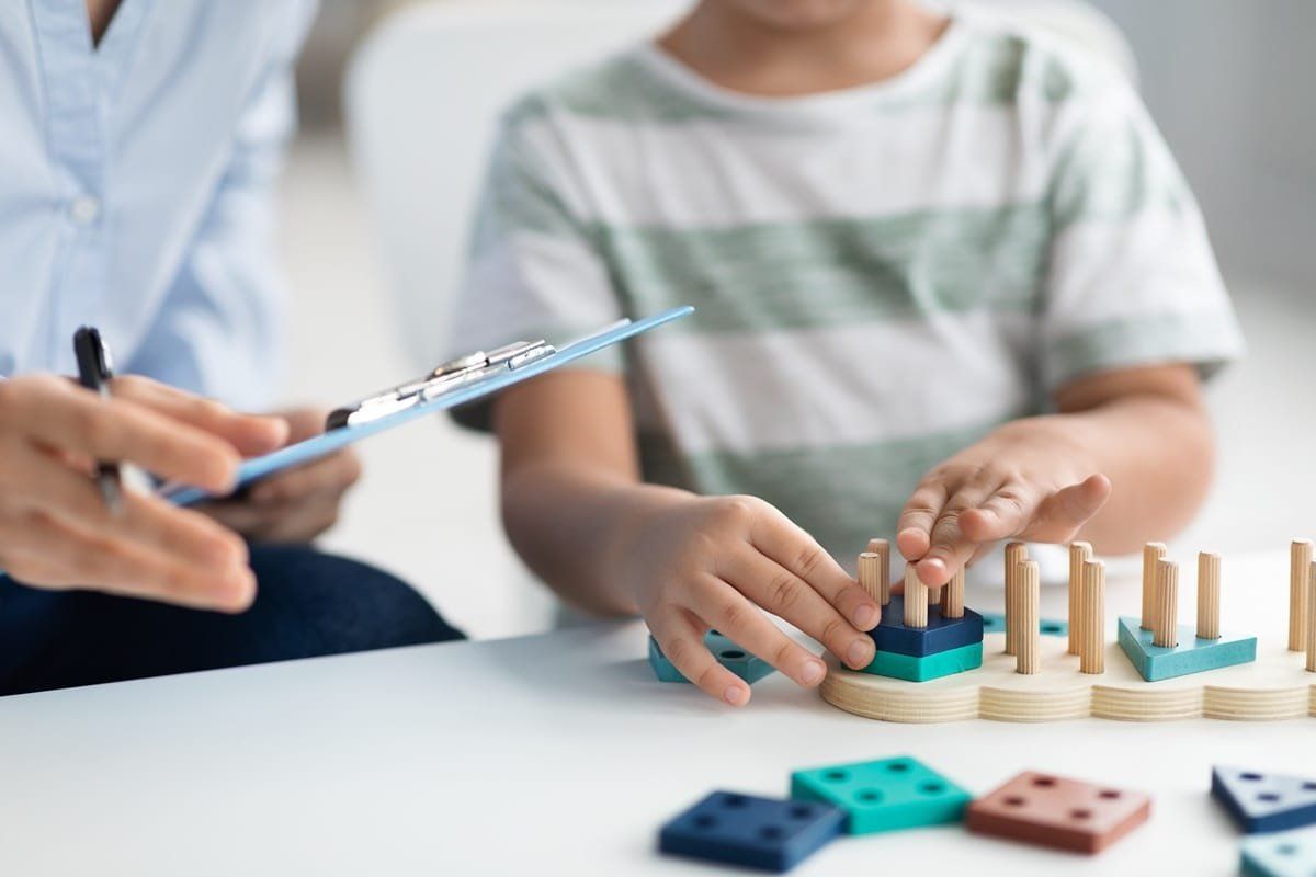 Kids development classes. Unrecognizable little boy playing logical game during psychological consultation, empty space