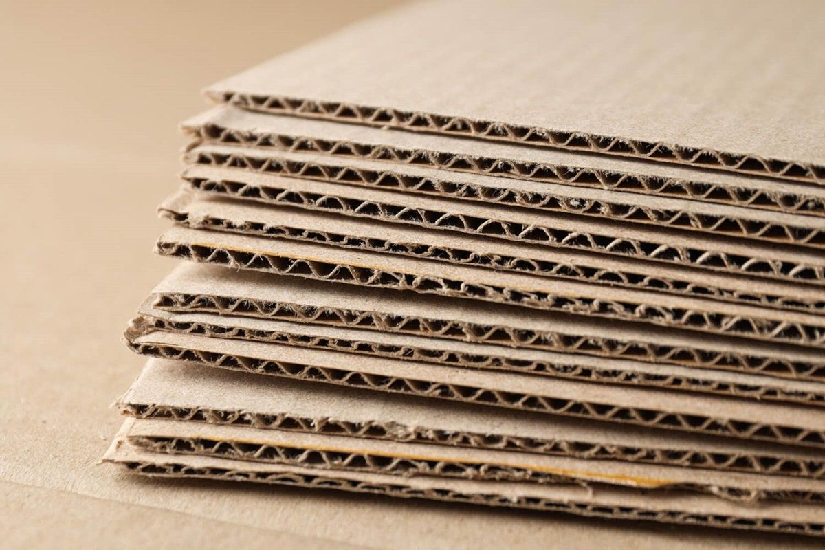Pila de láminas de cartón corrugado vista de canto, con las capas de flauta expuestas