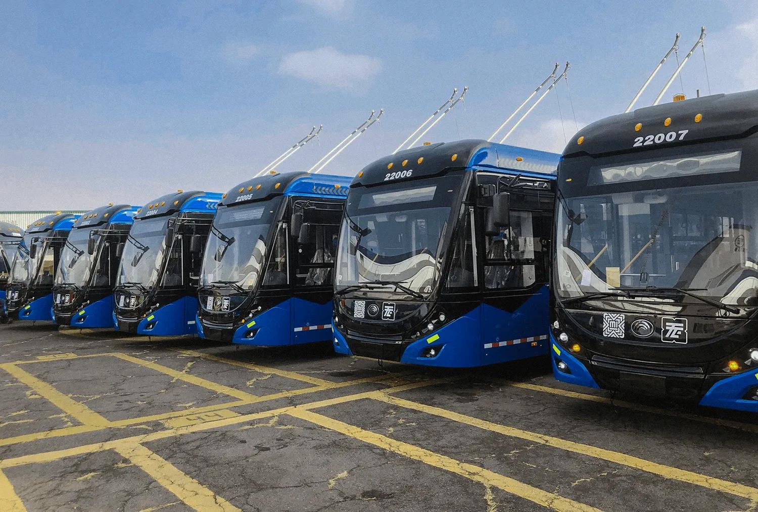 Fila de trolebuses azules estacionados en un patio de encierro de la Ciudad de México