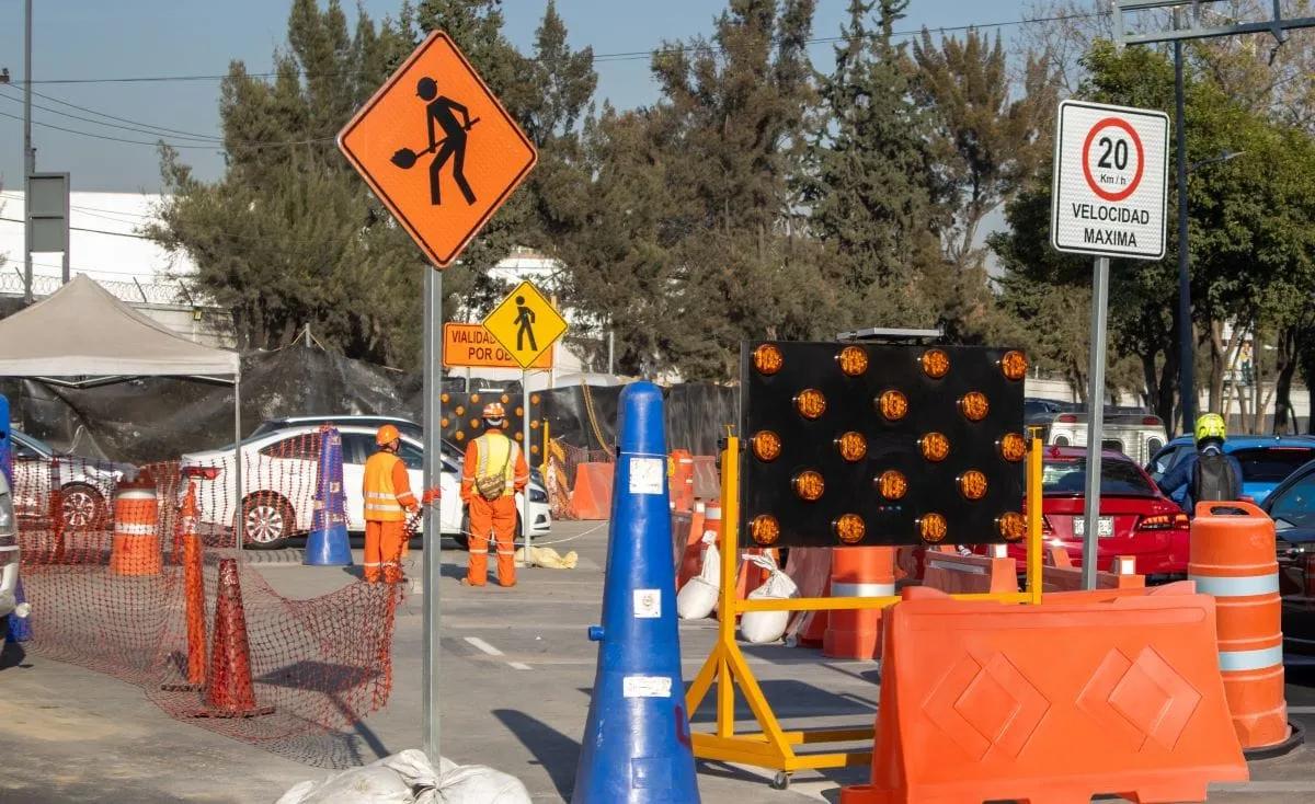 Obra en la Ciudad de México con señales, conos, un tablero de flechas y una Barrera Ray naranja