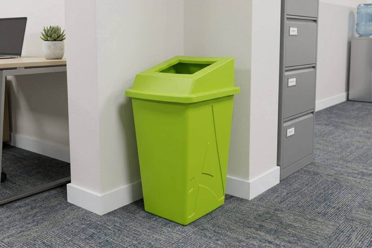 Contenedor de reciclaje de plástico color verde lima en una oficina junto a archiveros grises
