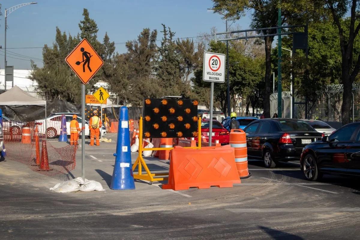 Obra en una avenida con flechero luminoso, barrera naranja, trafitambo, cono azul y señal de velocidad máxima de 20