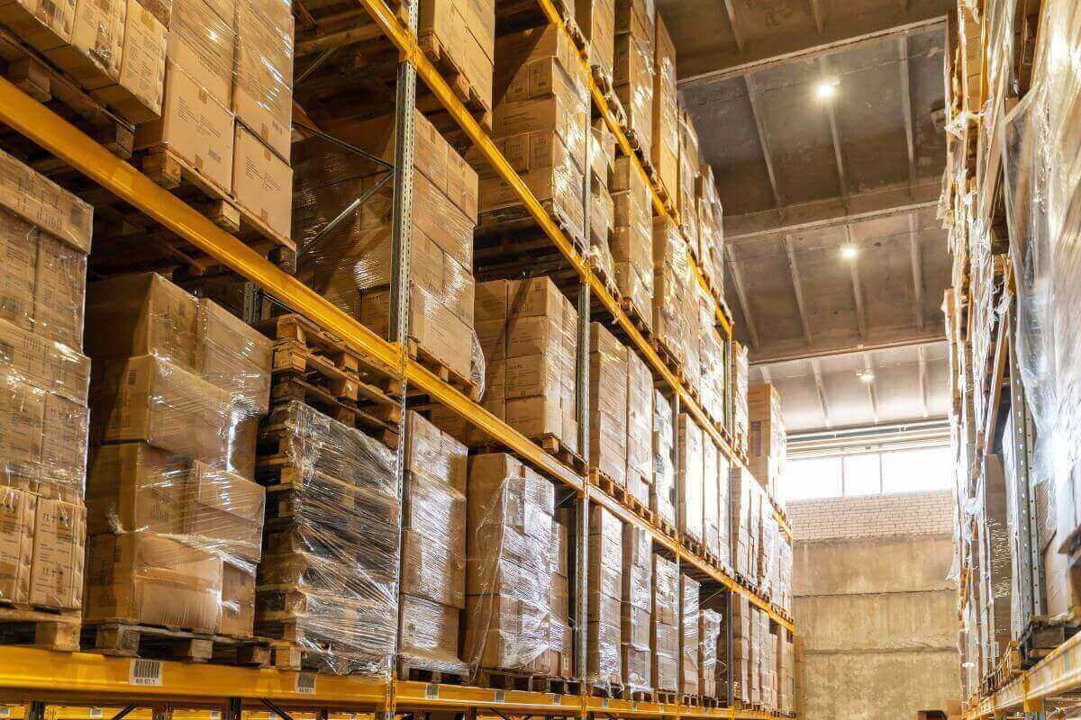 Racks de almacén con tarimas de cajas de cartón emplayadas con stretch film