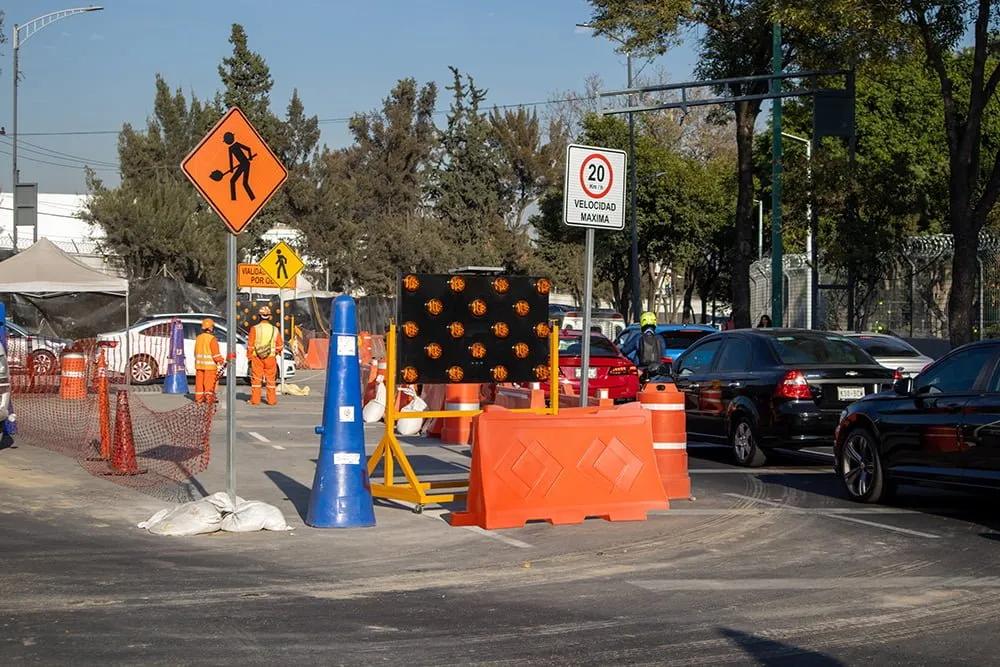 Flechero luminoso, cono azul y trafitambos desviando el tránsito en una avenida en obra de la CDMX
