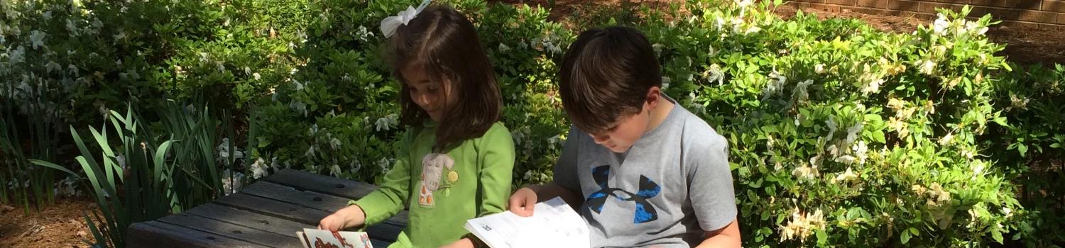 Young people sitting and reading books at a 2015 book sale event.