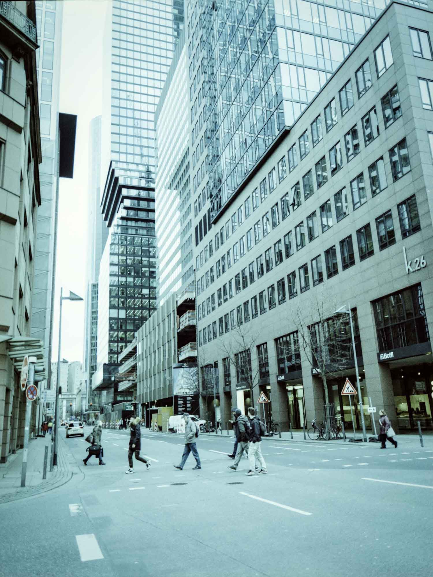 Straßenansicht mit Hochhäusern im Hintergrund.