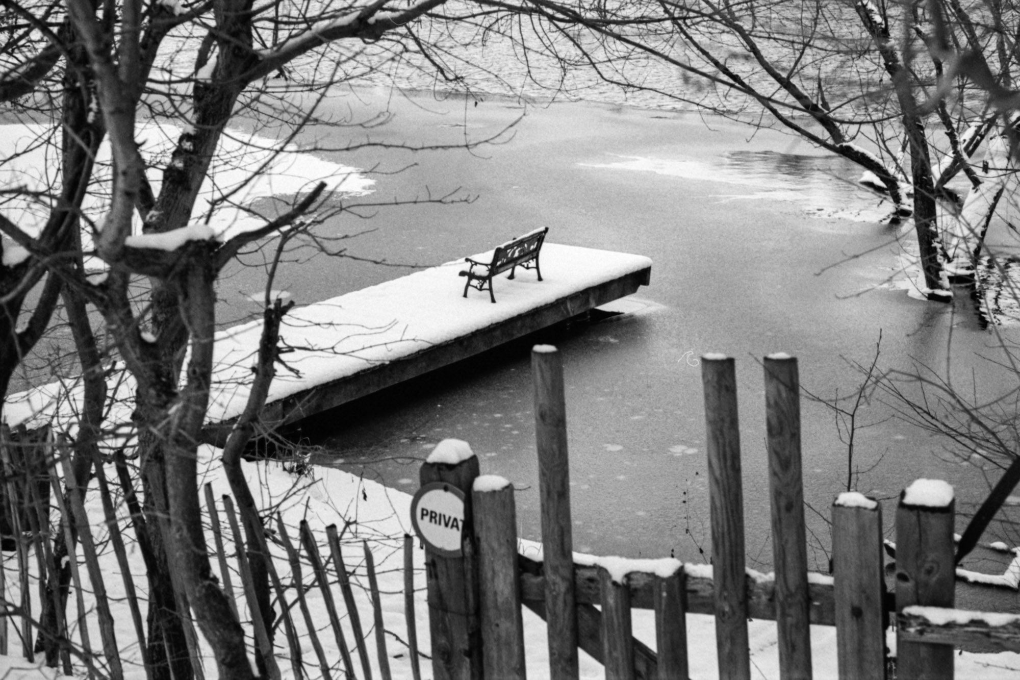 Schneebedeckte Bank an einer Anlegestelle.