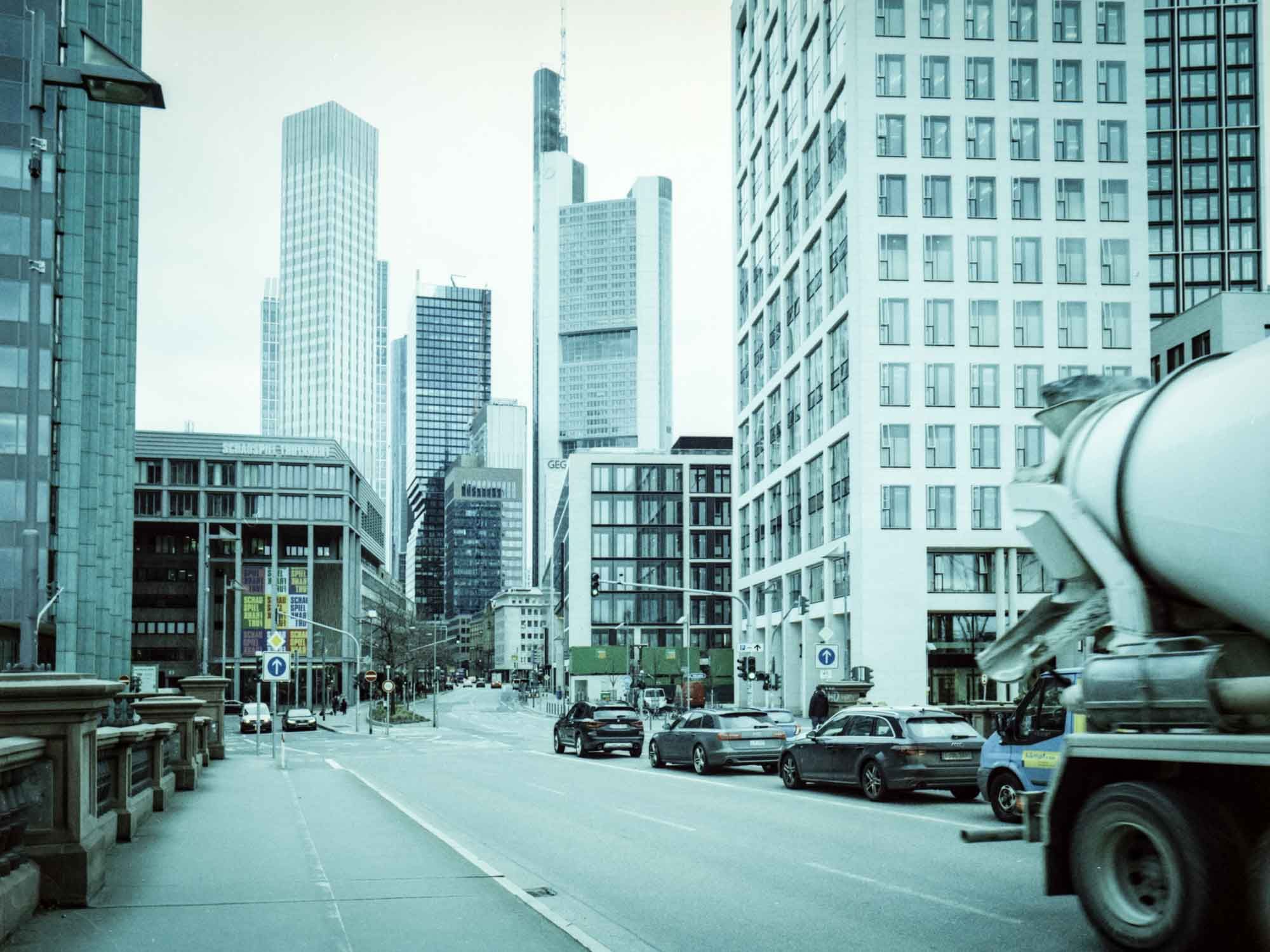 Straßenansicht mit Hochhäusern im Hintergrund.