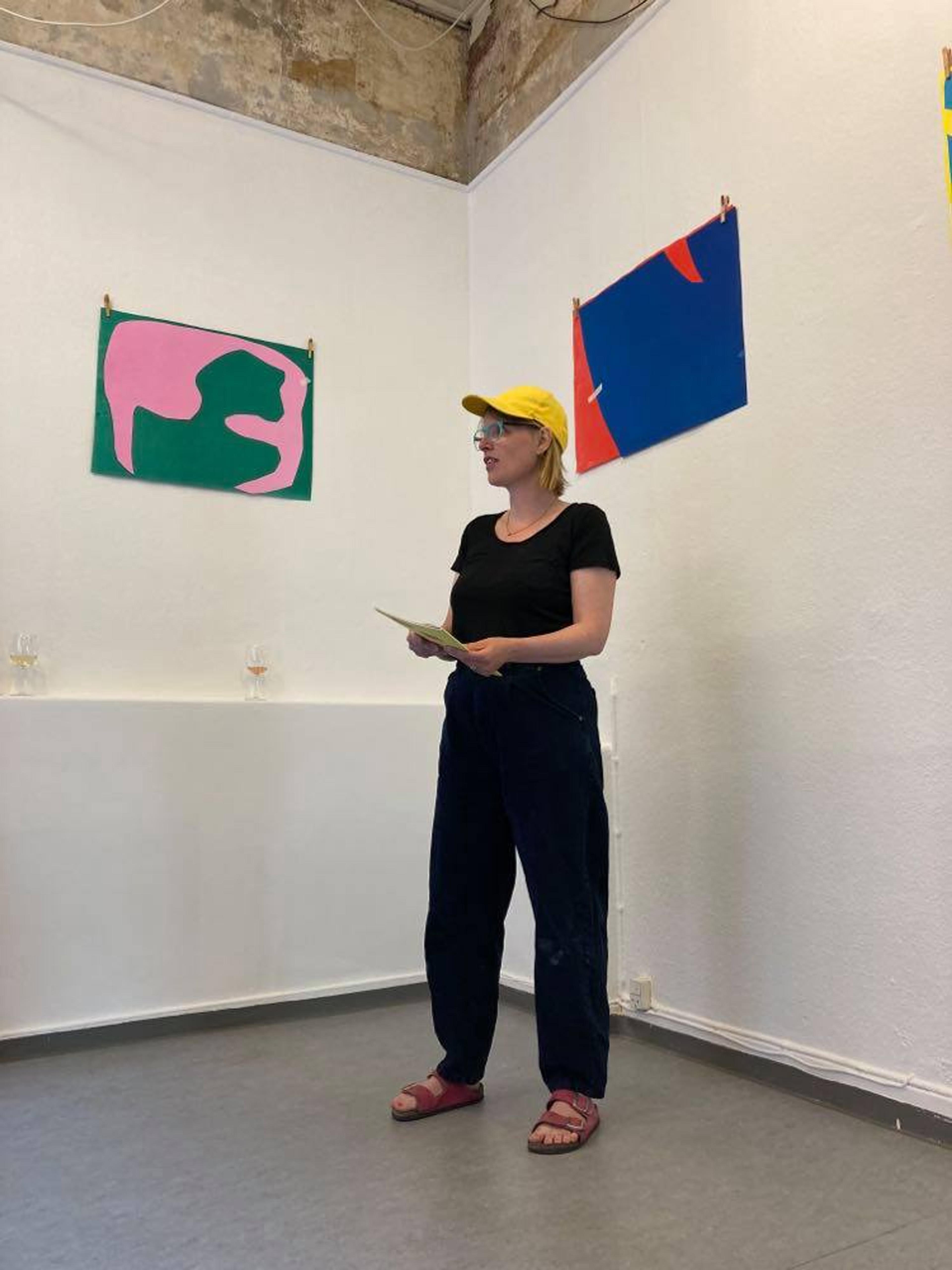 Maria Zahle standing in a gallery, speaking