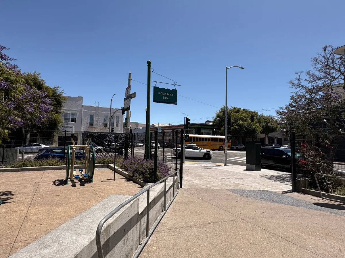 Corner entrance of Park. Note the open gates and sidewalk bordering fast traffic