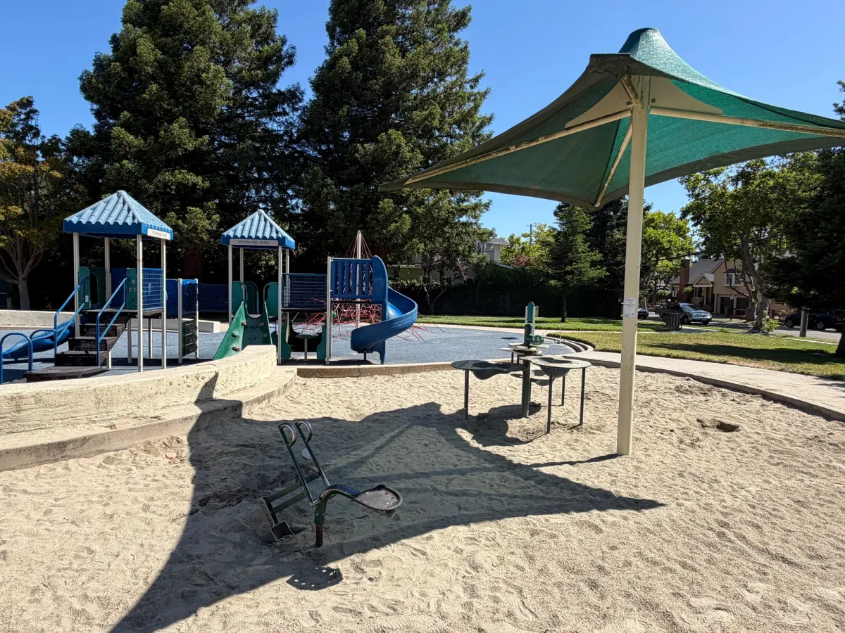 Shaded sand pit with a digger and sand table