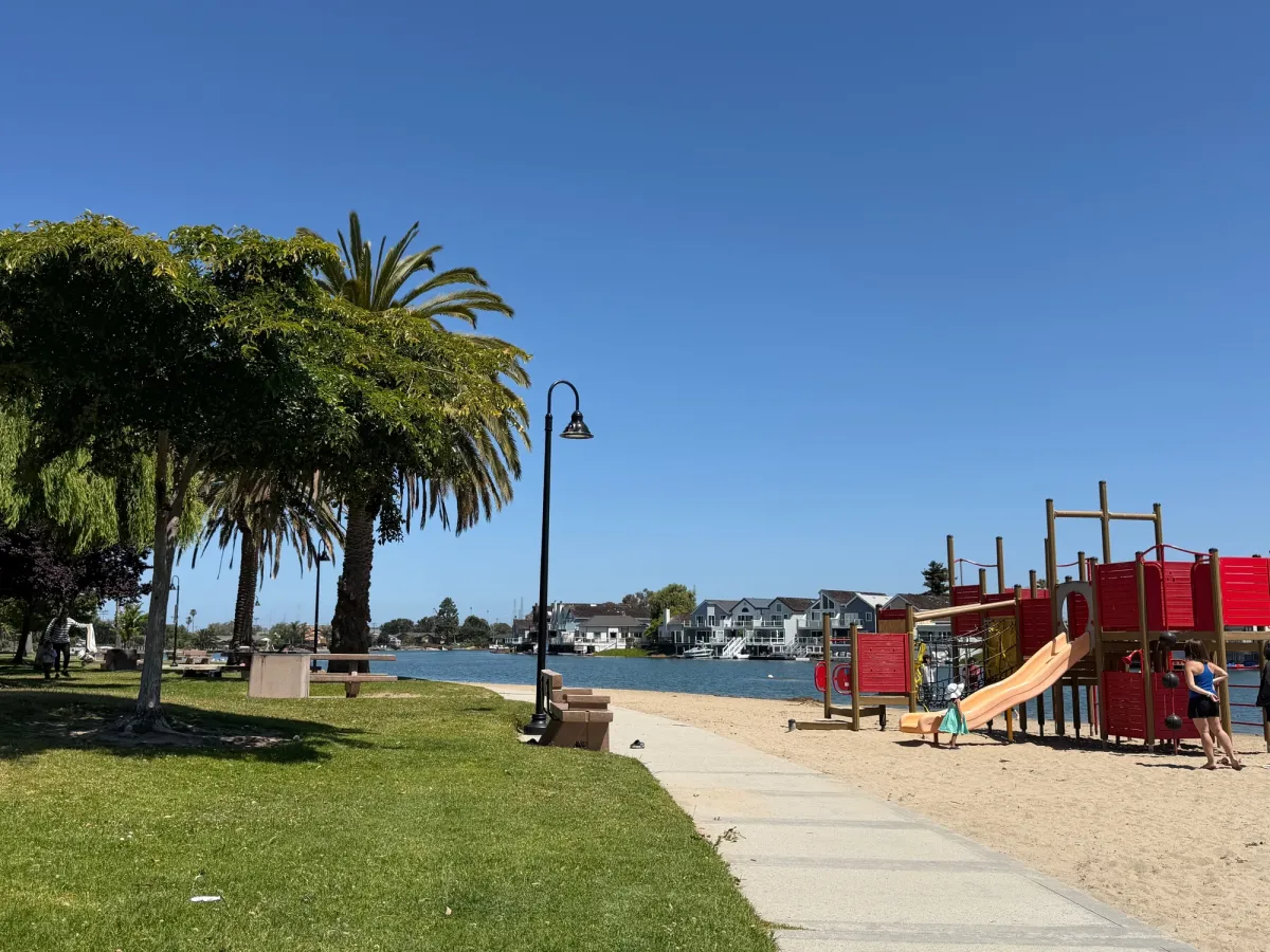 Several picnic tables with view of the lagoon and playground