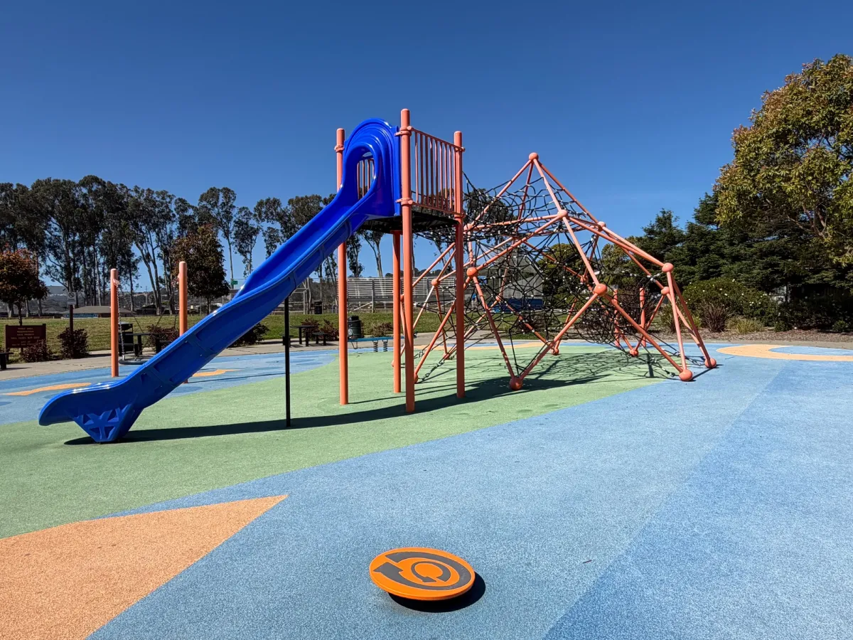 Tall slide connected to climbing structure