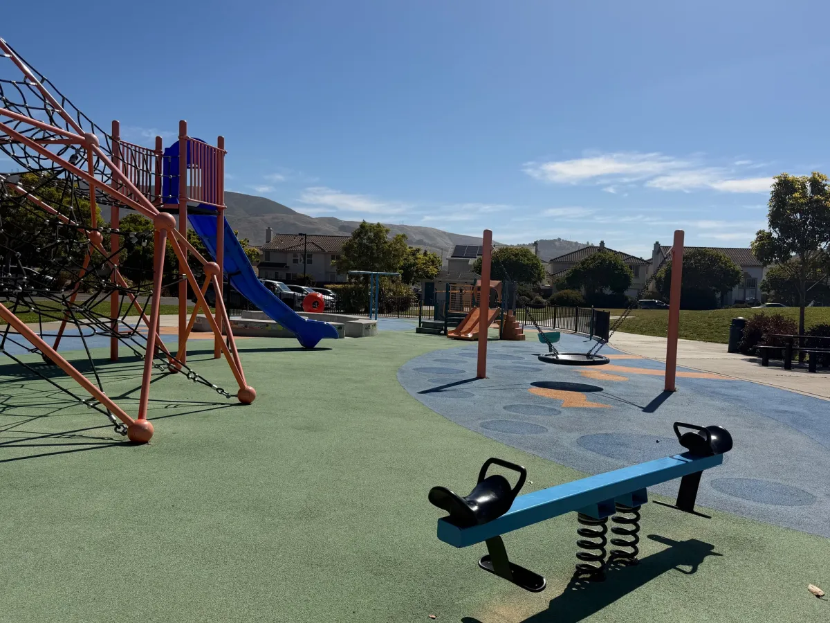 Toddler see saw, saucer swing, next to climbing structure and slide