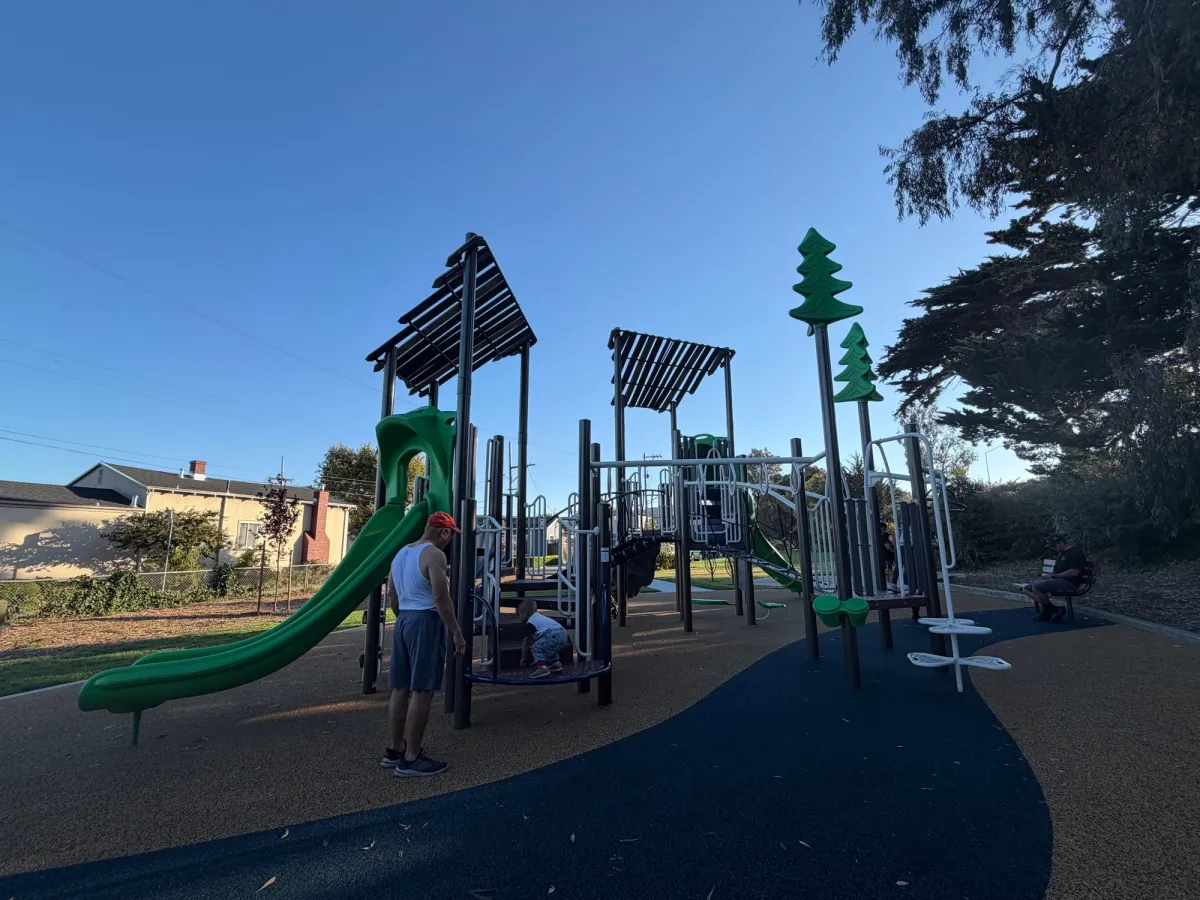 Playstructure with monkey bars, slides, and drums