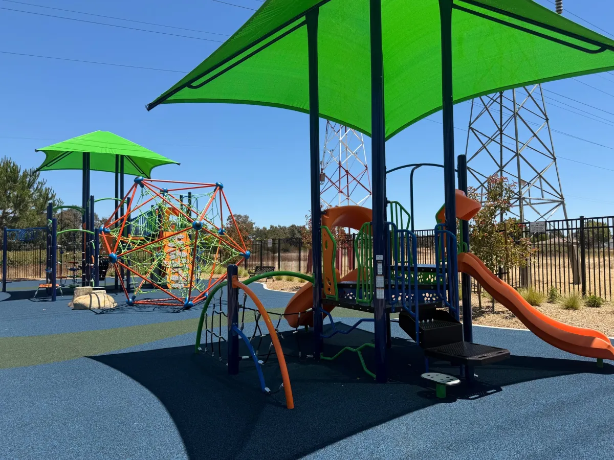 Big kid and toddler play zones with intricate climbing structure in middle