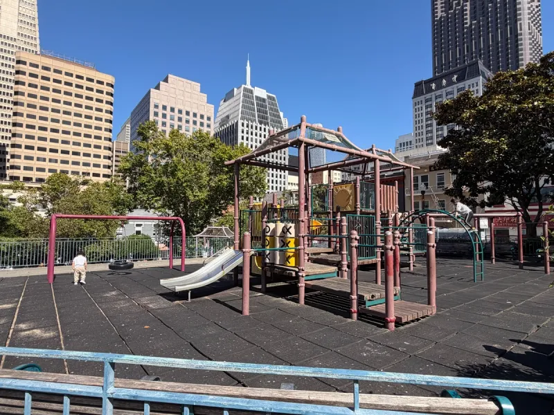 Big kid play structure includes slides, tire swing, climbers, and uneven bars