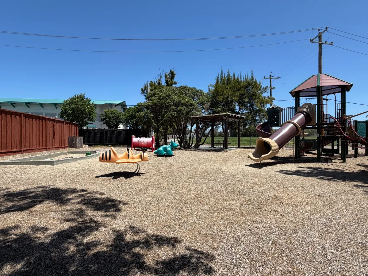 Sandbox and ride on toys next to big kid play structure - accessible to residents with key code only