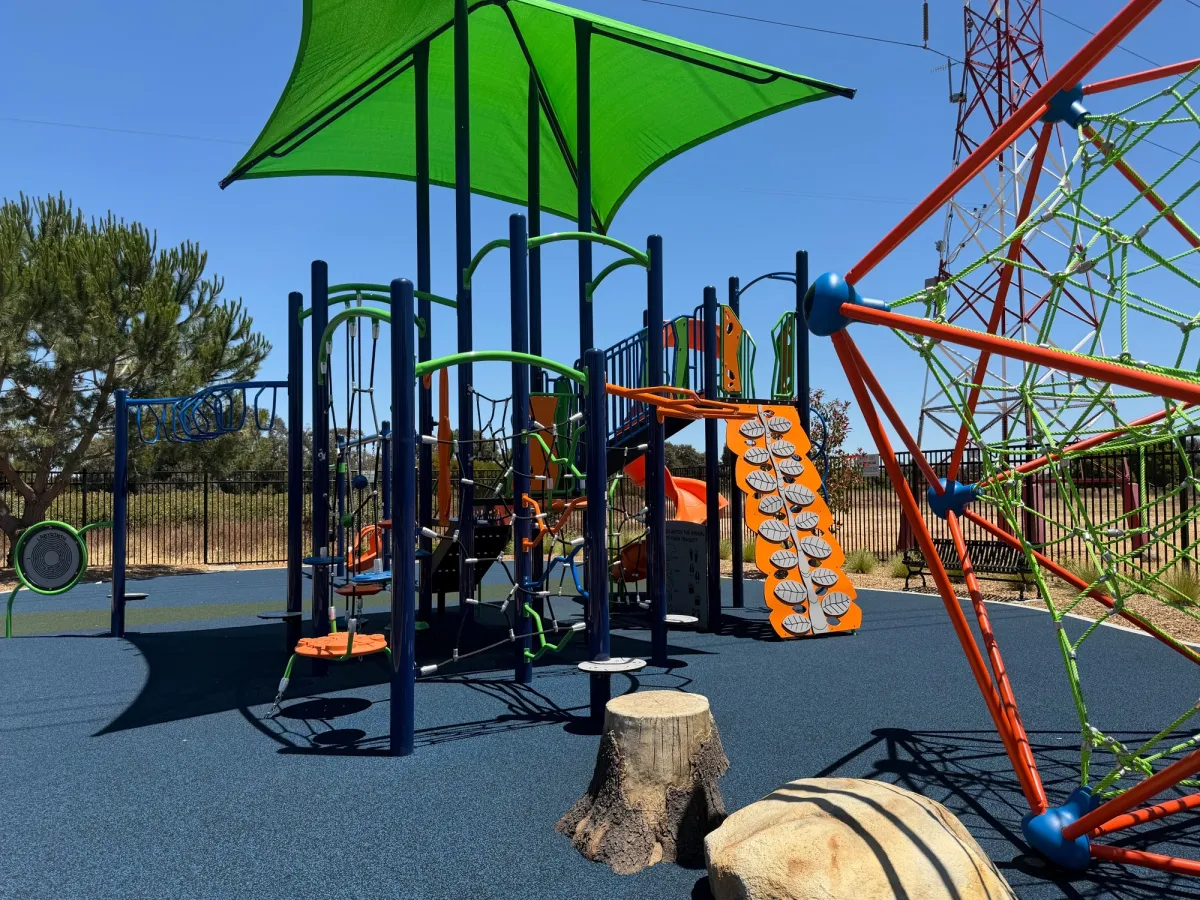 Great shade cover oversees older kid playground with lots of climbing structures to choose from