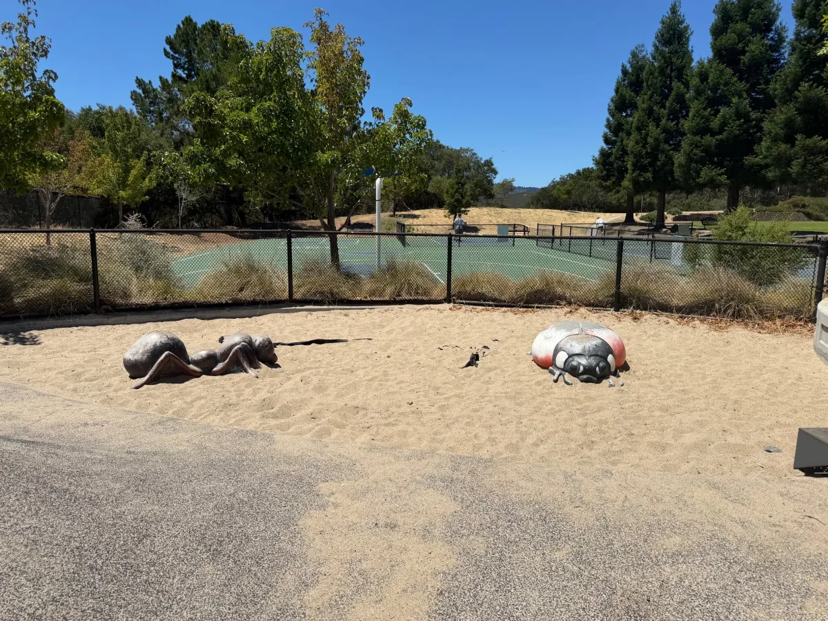 Insect statues in sandpit