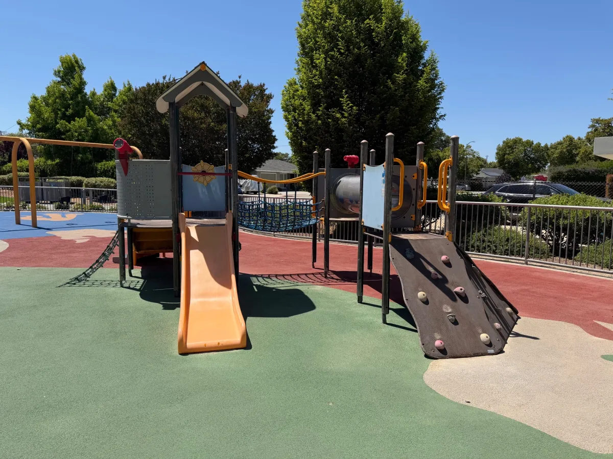 Toddler play structure with slides and rock wall