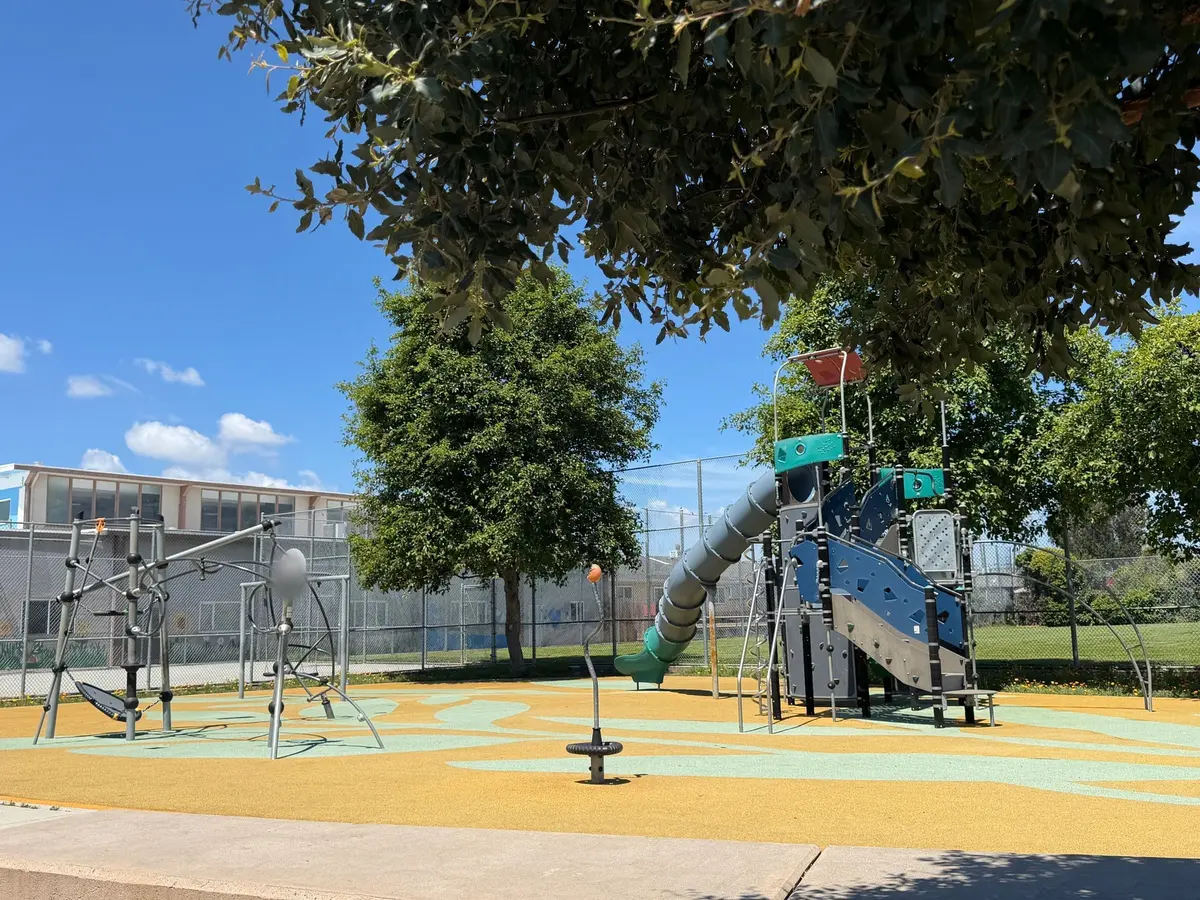 Big kid play structure with slides, climbing structure, and spinners