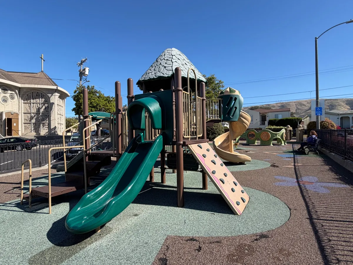 Toddler play structure with slide and rock climbing wall. Sensory panels in back