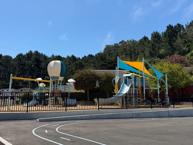 Toddler structure to the left and shade covered big kid structure to the right