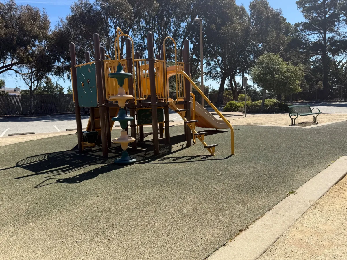 Toddler play structure with small climber, slide, drums, and under structure play area