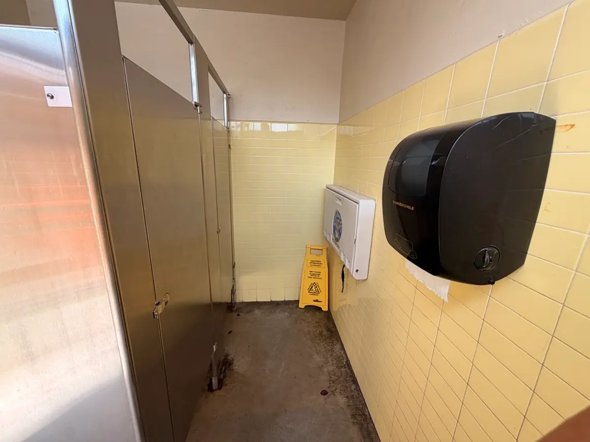 Small clean bathroom with a changing table. Then sink was out of order.