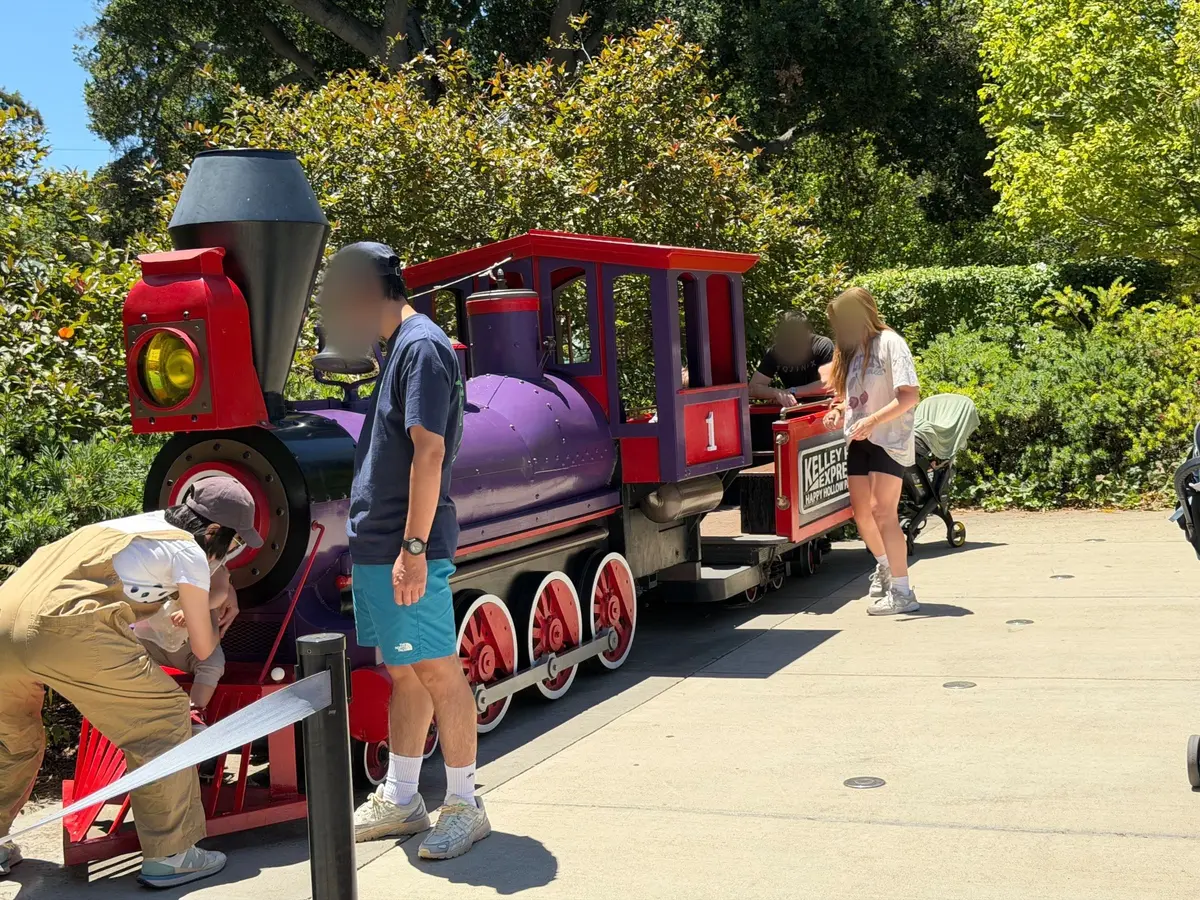Stationary train for kids to play while waiting for their older siblings to ride the train roller coaster