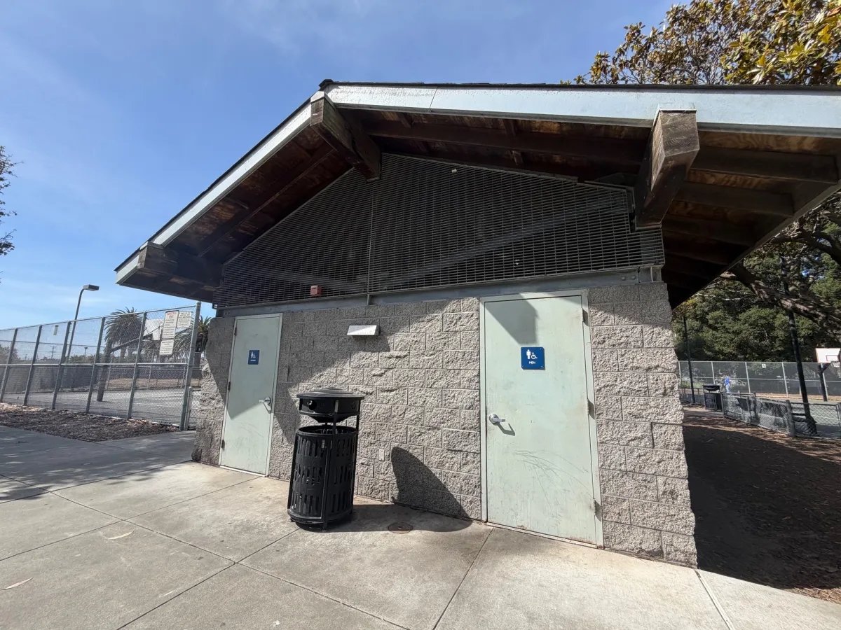 Bathrooms next to basketball courts, behind community center