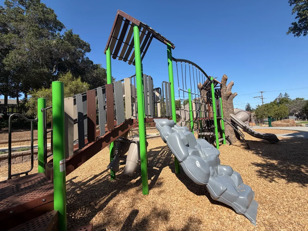Rock themed climbing ramp to big kid play structure