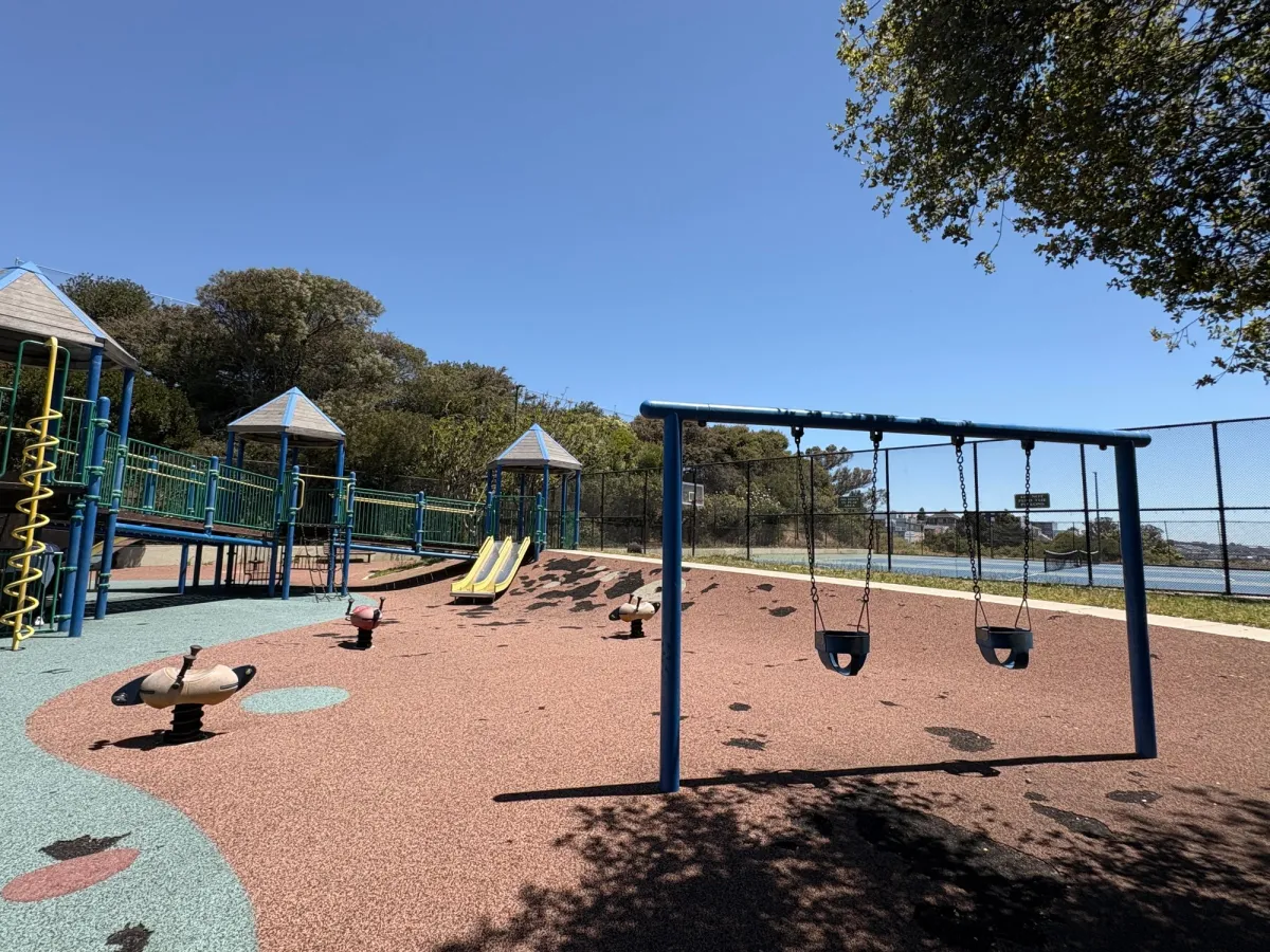 Bucket swings, smaller slides built in the hill and ride on toys