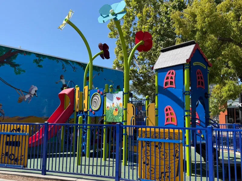 Enclosed toddler playground with musical sensory panels off to the side