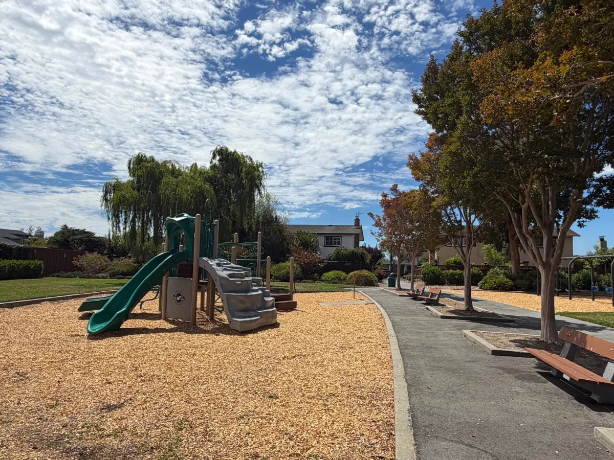Several benches with shade in front of playground