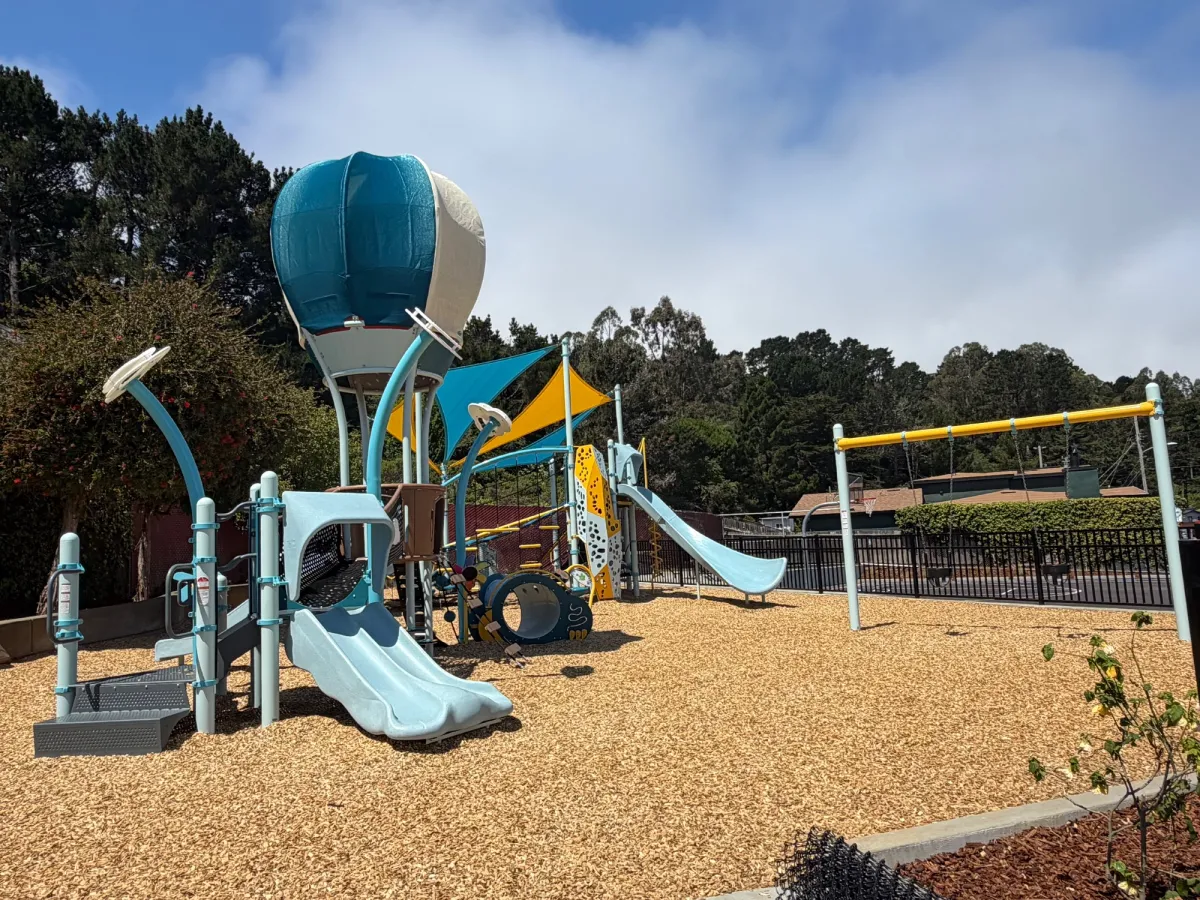 Toddler play structure shaped as hot air baloon amongst the clouds