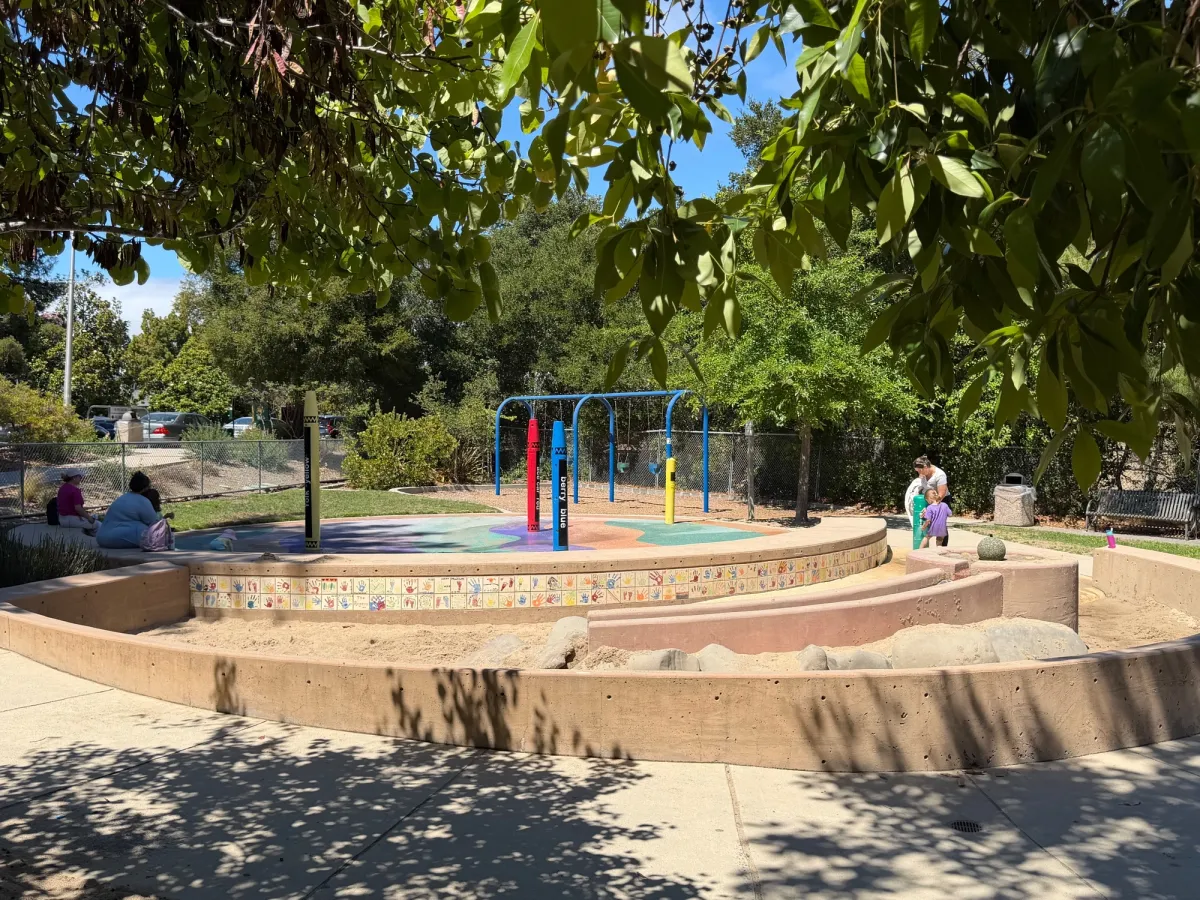 Splashpad area with baby swings in the back