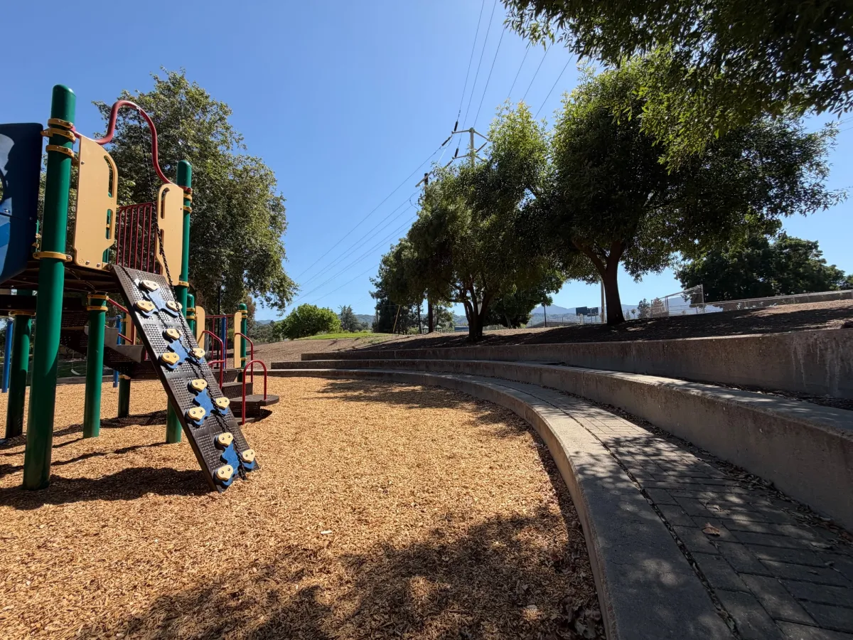 Shaded bleacher seating to watch the playground