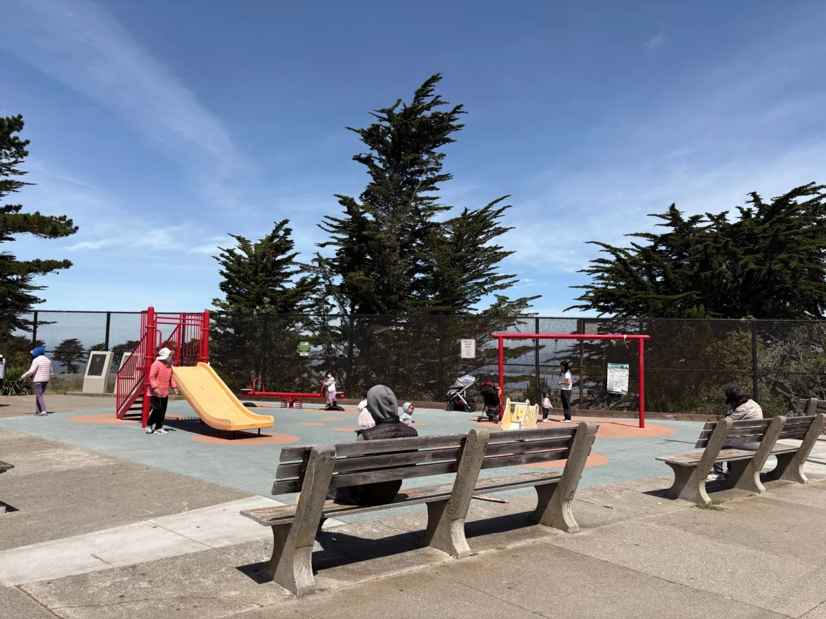 Corner view from the street. Not enclosed but has benches for parents to remain watchful