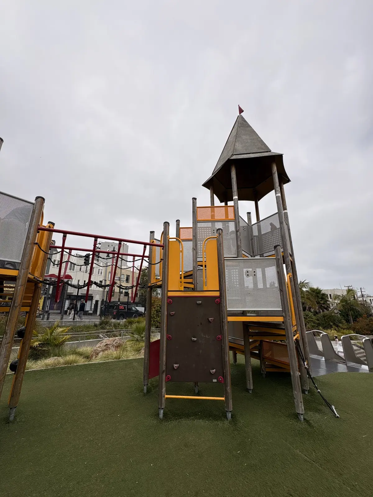 A tall play structure on the top of the hill