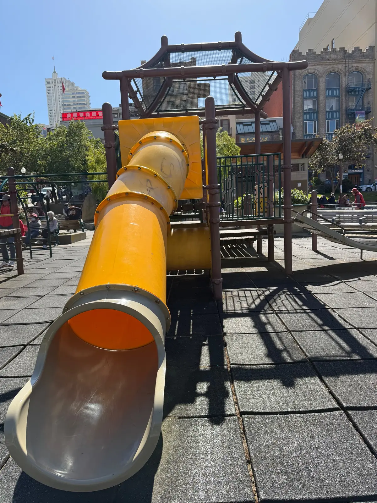 Tunnel slide in big kid playground next to parking garage elevators