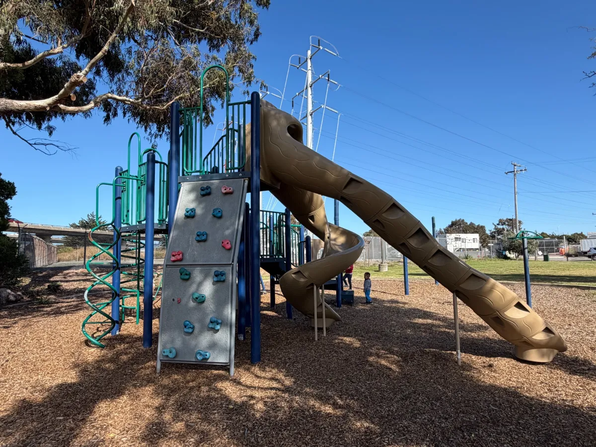 Back of play structure has a rock wall