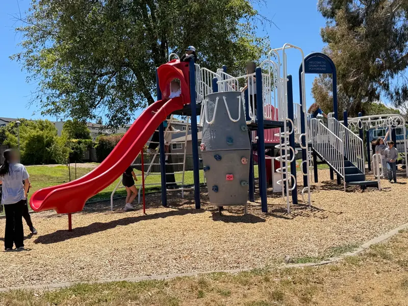 Big kid zone with slides, rock climbing wall, and monkey bars