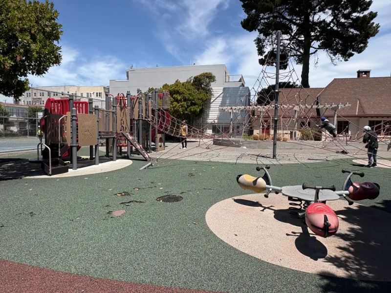 Wide shot of the playground, climbing gym, and tri-teeter totter