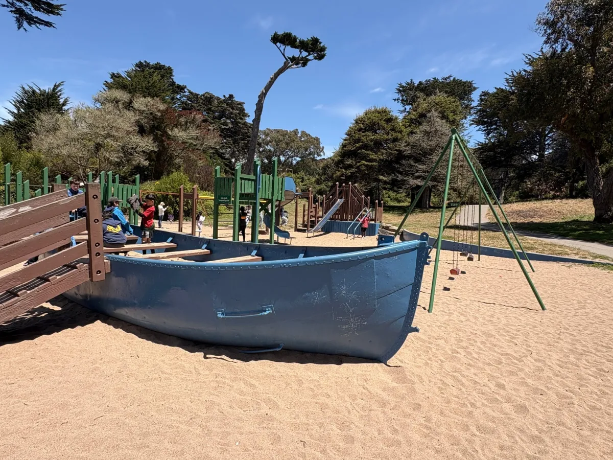 Side view of swings, boat, and several structures