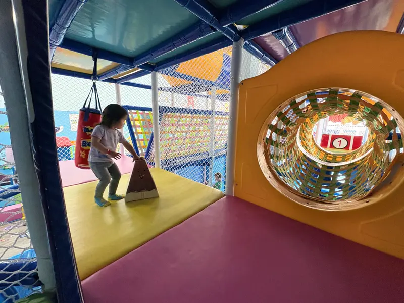 Kid plays in the upper layer of a play gym