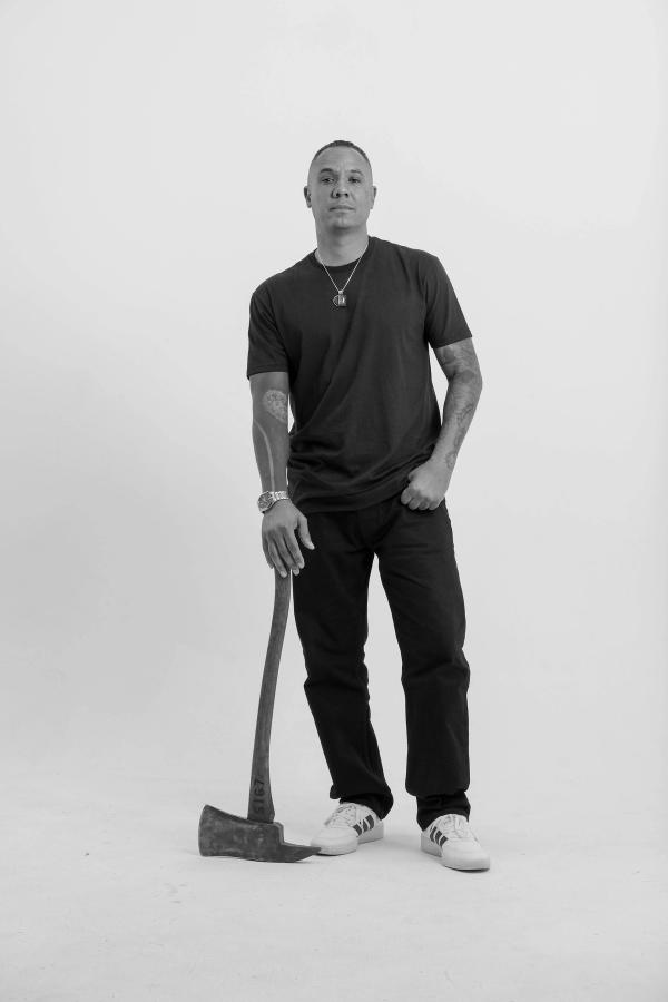Full-length portrait of a man standing with a firefighter’s axe