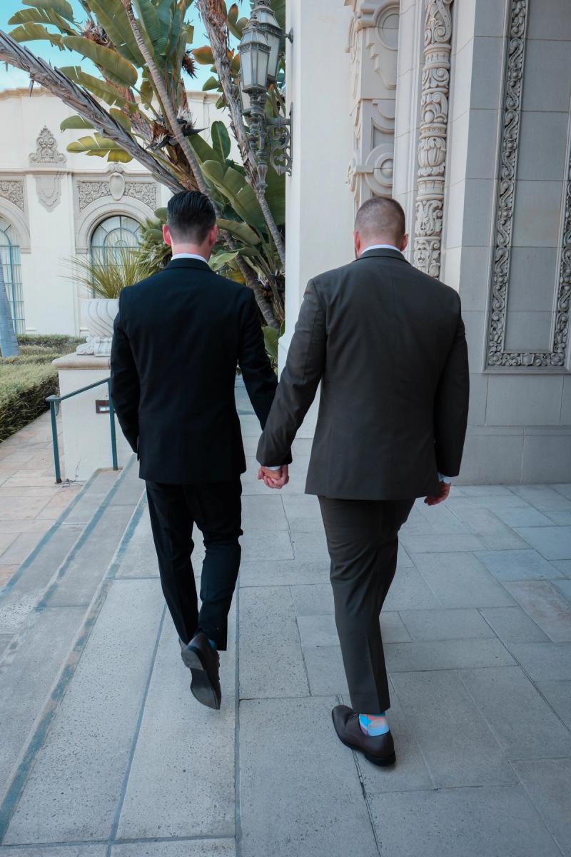 Grooms walking hand in hand down the city hall steps