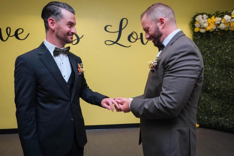 Grooms exchanging rings at the ceremony